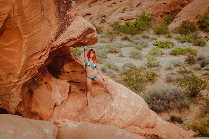 Bianca Beauchamp under a red sandstone arch in the desert